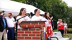 Memorial Day 2024.  Twin sisters Addison and Delaney McDaniel recite the Pledge of Allegiance. They are the grandchildren of Bob and Marie Gilmore. Marie is off to the right in the red blouse.
